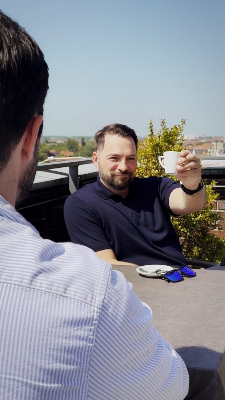 Mann hält Tasse hoch